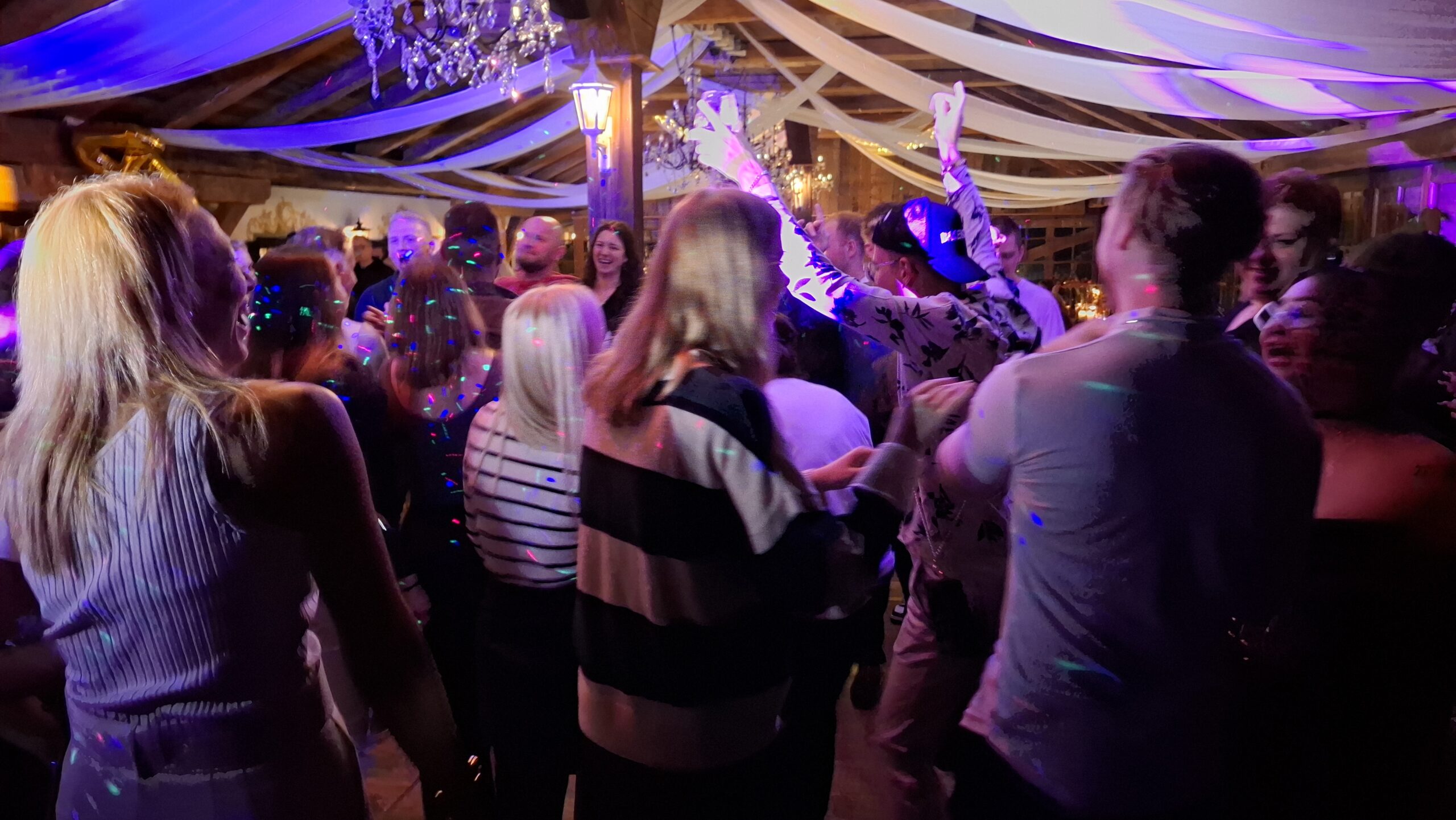 Volle Tanzfläche bei einer Hochzeit im festlich geschmückten Stadl in Oberbayern